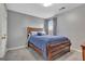 Cozy bedroom featuring a wood frame bed, blue bedding, and a window with curtains at 306 Turtle Pointe Dr, Carrollton, GA 30116