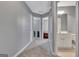 Hallway view of bathroom and bedroom featuring neutral walls, carpeting, and multiple doorways at 306 Turtle Pointe Dr, Carrollton, GA 30116