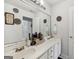 Bright bathroom features a dual sink vanity with large mirror, decorative accents and white cabinetry at 10119 Azalea Dr, Covington, GA 30014
