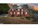 Charming two-story brick home with manicured landscaping, a retaining wall, and welcoming front porch at 10119 Azalea Dr, Covington, GA 30014