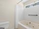 Bathroom featuring a jetted tub with tile surround and a window for natural light at 290 Rocky Branch Dr, Mcdonough, GA 30252