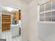 Bright laundry room with white appliances, window, and wooden storage at 290 Rocky Branch Dr, Mcdonough, GA 30252