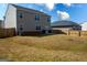 Well-maintained backyard with healthy grass, a young tree, and the home's exterior with trash receptacles at 443 Faulkner St, Stockbridge, GA 30281