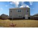 Backyard featuring grass, a young tree, trash cans, and a view of the house with plenty of windows at 443 Faulkner St, Stockbridge, GA 30281