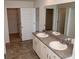 Bathroom featuring double sinks with cabinets below, a large mirror, and tile floors at 443 Faulkner St, Stockbridge, GA 30281
