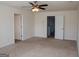 Spacious carpeted bedroom with a ceiling fan and white doors to other rooms at 443 Faulkner St, Stockbridge, GA 30281
