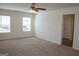Spacious bedroom with carpet flooring, two windows, and an open doorway at 443 Faulkner St, Stockbridge, GA 30281