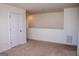 Spacious bonus room featuring neutral carpeting, a well-lit area, and a classic paneled door at 443 Faulkner St, Stockbridge, GA 30281