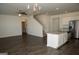 Open-concept living room with hardwood floors, staircase, kitchen island, and stainless steel refrigerator at 443 Faulkner St, Stockbridge, GA 30281