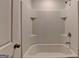 Well-maintained bathroom featuring tiled shower with built-in shelves and a sleek, modern tub at 1659 Hay Patch Ln, Loganville, GA 30052