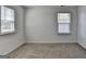 Cozy bedroom featuring soft carpeting and two windows, providing natural light and a pleasant view at 1659 Hay Patch Ln, Loganville, GA 30052