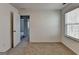 Bright bedroom with a window, white walls, and carpeted floor at 1659 Hay Patch Ln, Loganville, GA 30052