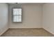 This bedroom has a window for natural light and neutral carpeting at 1659 Hay Patch Ln, Loganville, GA 30052