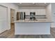 Open kitchen features a spacious island with sink, granite countertop, and white base cabinets at 1659 Hay Patch Ln, Loganville, GA 30052