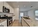 Bright kitchen features stainless steel appliances, granite countertops, and wood-look flooring at 1659 Hay Patch Ln, Loganville, GA 30052