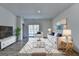 Modern living room with neutral decor, area rug, and sliding doors to the outside at 1659 Hay Patch Ln, Loganville, GA 30052