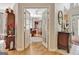 Inviting interior view through French doors, showcasing hardwood floors and an elegant home office with built-in shelves at 221 Collierstown Way, Peachtree City, GA 30269