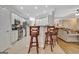 Open-concept kitchen with white cabinets, granite countertops, and bar seating overlooking the living area at 221 Collierstown Way, Peachtree City, GA 30269