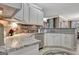 Stylish kitchen featuring granite countertops, stainless steel appliances, white cabinetry, and a tile backsplash at 221 Collierstown Way, Peachtree City, GA 30269
