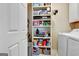 Laundry room featuring a shelving unit stocked with storage items and a washing machine at 221 Collierstown Way, Peachtree City, GA 30269