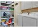 Bright laundry room with white appliances, storage shelves, and a sewing machine at 221 Collierstown Way, Peachtree City, GA 30269