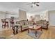 Bright living room with hardwood floors, ceiling fan, two sofas, and an open view into the kitchen at 221 Collierstown Way, Peachtree City, GA 30269