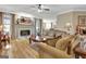 Comfortable living room with a fireplace, wood floors, neutral tones, and a view into the dining area at 221 Collierstown Way, Peachtree City, GA 30269