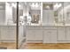 Bright main bathroom featuring double sinks, white cabinets, large mirrors and vanity lighting at 221 Collierstown Way, Peachtree City, GA 30269