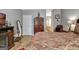 Spacious main bedroom with a comfortable bed, armoire, sitting chair, and decorative mirror at 221 Collierstown Way, Peachtree City, GA 30269