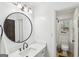 Bright bathroom featuring a modern vanity with a round mirror and adjacent shower at 179 Green Valley Rd, Fayetteville, GA 30214