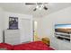 Comfortable bedroom with a red comforter, white furniture, a ceiling fan, and a large TV at 179 Green Valley Rd, Fayetteville, GA 30214