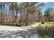View of the driveway leading to the property with trees and waste bins on the side at 179 Green Valley Rd, Fayetteville, GA 30214