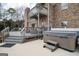 Backyard patio featuring a hot tub, outdoor seating, and brick exterior at 90 Oak Walk, Villa Rica, GA 30180