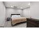 Basement bedroom has comfortable queen bed with beige blanket and dark dresser at 90 Oak Walk, Villa Rica, GA 30180