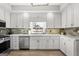 Bright kitchen showcasing white cabinetry, a stainless steel dishwasher, and modern fixtures at 90 Oak Walk, Villa Rica, GA 30180