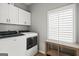 Functional laundry room with washer, dryer, and ample storage cabinets above at 90 Oak Walk, Villa Rica, GA 30180
