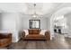 Inviting living room with leather furniture, a modern light fixture, and wood floors at 90 Oak Walk, Villa Rica, GA 30180