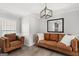 Cozy living room with leather furniture, a modern light fixture, and wood floors at 90 Oak Walk, Villa Rica, GA 30180