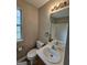 Well-lit bathroom with a white sink vanity, toilet, and a mirror reflecting the shower-tub at 741 S Fairfield Dr, Peachtree City, GA 30269