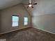 Spacious carpeted bedroom with vaulted ceilings, two windows, and neutral paint at 741 S Fairfield Dr, Peachtree City, GA 30269