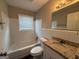 Bathroom featuring a shower and tub combo, tile walls and a granite vanity at 1643 Columbia Dr, Decatur, GA 30032