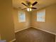 Neutral bedroom with two windows, ceiling fan, and neutral carpet at 192 Margaret St, Fairburn, GA 30213