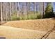 View of the backyard features a terraced landscape and mature trees, great for privacy at 2455 Westlington Cir, Cumming, GA 30040