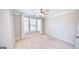 Cozy bedroom featuring a large window, neutral carpet, and a ceiling fan at 2455 Westlington Cir, Cumming, GA 30040