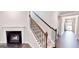 Inviting entryway with hardwood floors, a staircase with wooden railing and a fireplace, creating a warm ambiance at 2455 Westlington Cir, Cumming, GA 30040