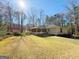 Backyard featuring a screened-in porch, a lush lawn, and mature trees providing privacy and shade at 127 Circle H Rd, Sharpsburg, GA 30277