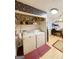 Laundry room with floral wallpaper and utility sink adjacent to an office desk at 127 Circle H Rd, Sharpsburg, GA 30277