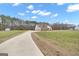 View of long concrete driveway leading to a beautiful home with a spacious yard at 196 Old Highway 92, Fayetteville, GA 30215