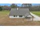 The back of the home features white siding, a stone foundation, and a covered patio with outdoor seating at 196 Old Highway 92, Fayetteville, GA 30215