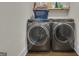 Modern laundry room with front-load washer and dryer and upper shelves for extra storage at 196 Old Highway 92, Fayetteville, GA 30215